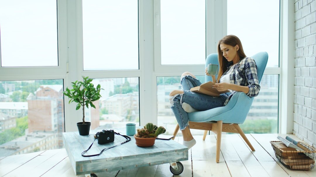 woman reading book by window